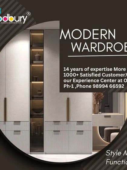 This design shows how a wardrobe can be a complete storage solution. It features a mix of closed cabinets, drawers, and an open, lit-up glass shelf for display, along with an integrated dressing table area.