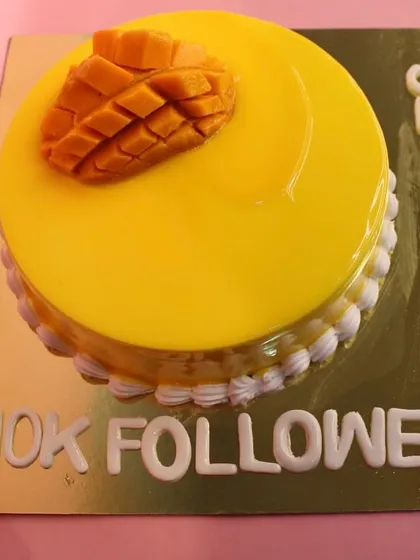Another angle of the custom mango cake, showcasing the "Congrats 10k Followers" message crafted with precision.