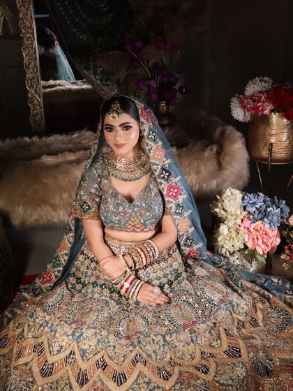 A wide shot showing the bride seated, with her lehenga spread out, creating a grand and royal image.