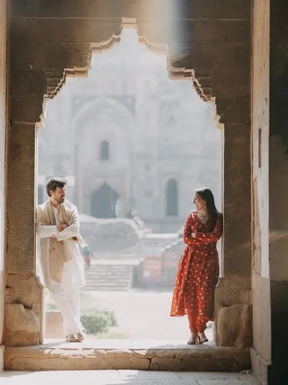 Using the beautiful architecture of Lodhi Garden in Delhi to frame a quiet moment. The rays of light add a magical, cinematic quality to this pre-wedding photo.
