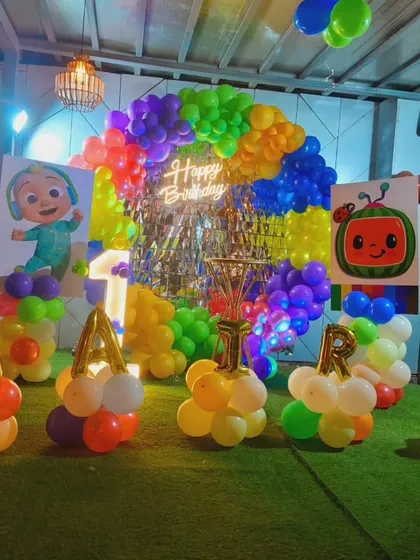Another view of the Cocomelon party setup, showing the name 'ARTR' spelled out with balloon stands.
