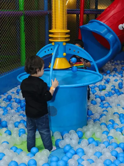 A young explorer enjoying the ball fountain feature inside our large ball pit.