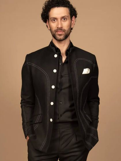 A confident pose in the black contrast-stitched Bandhgala. This piece is a fusion of tradition and modernity, perfect for the man who appreciates unique details.