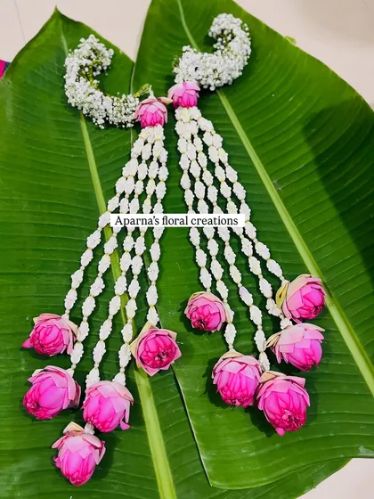 A beautiful set of fresh floral bajuband (armlets) made with white buds and pink lotus flowers, perfect for a traditional Dohale Jevan look.