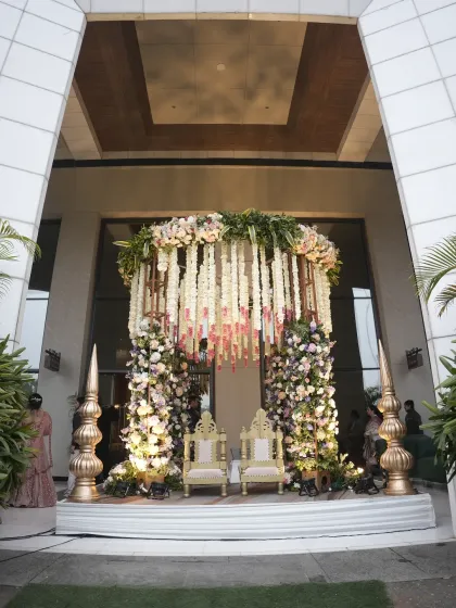 A unique seating arrangement designed for the wedding ceremony, featuring ornate chairs under a canopy of hanging floral strings. This setup at Karma Lakelands provided a beautiful photo opportunity for the couple.