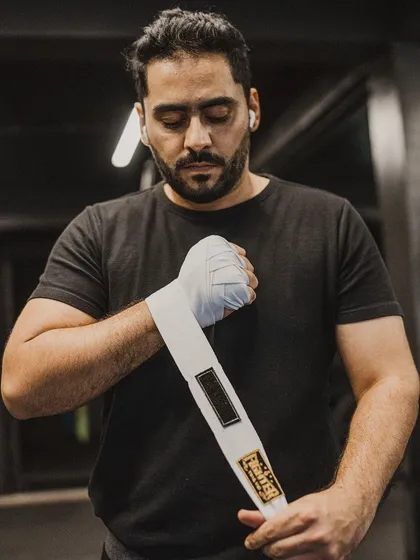 A close-up of a fighter wrapping his hands, showing the detail of the process.