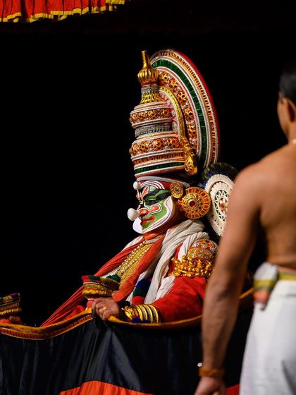 A behind-the-scenes style shot, capturing the performer on stage from the perspective of the audience, adding depth and context.