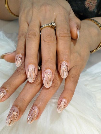 A unique and elegant design with a sheer, milky base and delicate, wavy lines of rose gold chrome, creating a marble-like effect.