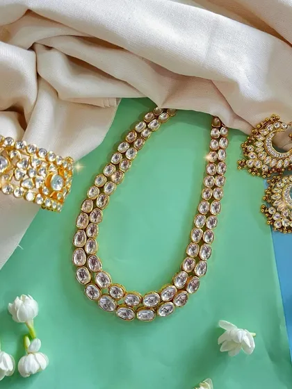 Add a touch of royalty to your collection with this stunning Kundan jewellery set. The intricate work and classic design make it a perfect choice for grand celebrations.