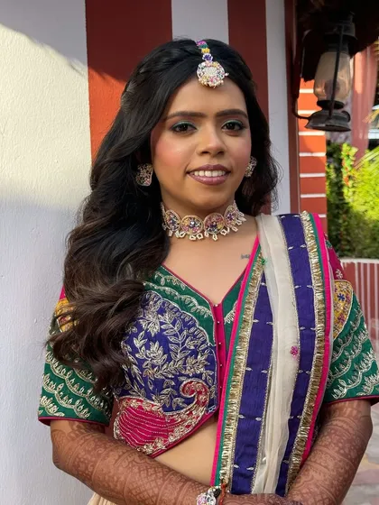 The bride-to-be looking lovely for her Haldi ceremony. The half-up hairstyle with braids and waves perfectly matches the festive and colorful vibe.