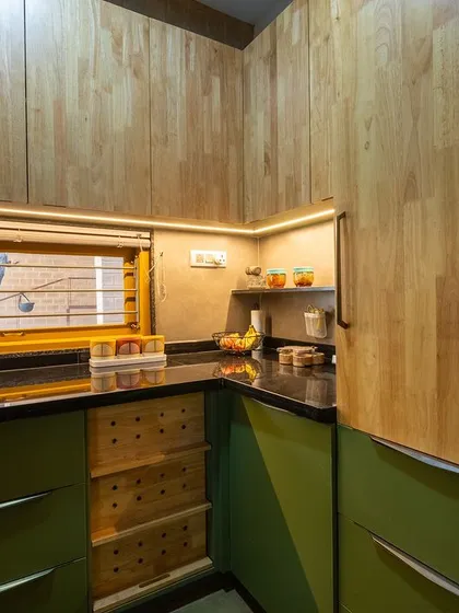 This view of the Audumbara kitchen highlights the combination of olive green lower cabinets and warm rubberwood upper cabinets, along with custom wicker drawers.