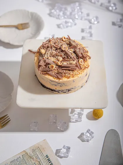 An overhead view of our Mango and Chocolate ice cream cake, showcasing the generous topping of chocolate shavings and hazelnuts.