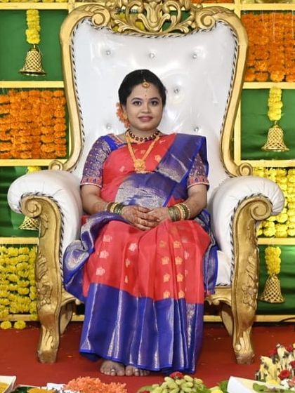 A beautiful mommy-to-be ready for her baby shower. She is seated on a throne, looking absolutely regal in her silk saree with makeup that enhances her pregnancy glow.