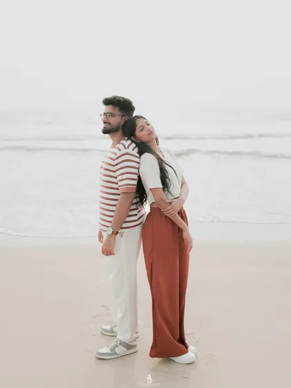 A serene pose, standing back-to-back against the calming ocean waves. This composition adds a sense of balance and quiet strength to the portrait.