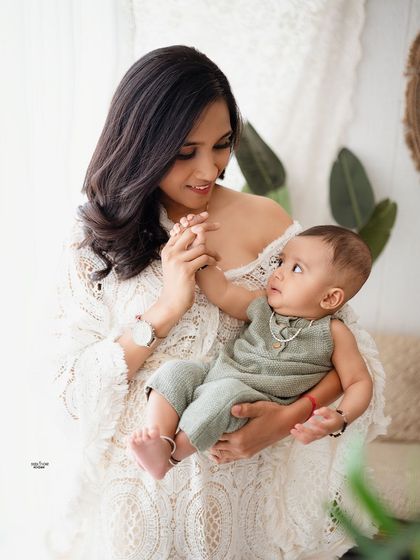 A mother and her baby sharing a sweet, interactive moment.