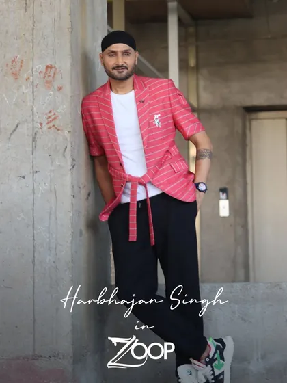 A full-length shot of Harbhajan Singh in the custom red blazer set. The relaxed posture and confident smile show he feels as good as he looks in this distinctive piece.