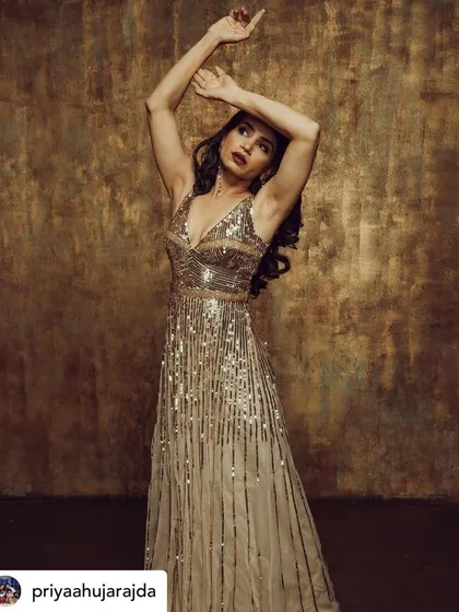 An artistic and expressive pose. The makeup is designed to highlight her features and look stunning under studio lighting.