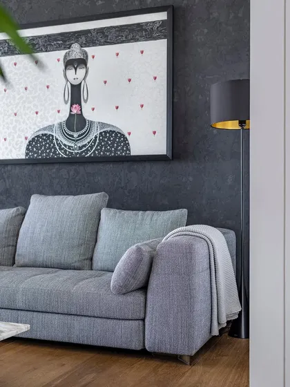 The interplay of textures is key in this living room. The soft fabric of the sofa contrasts with the cool marble of the coffee table and the rough texture of the wall, creating a rich sensory experience.