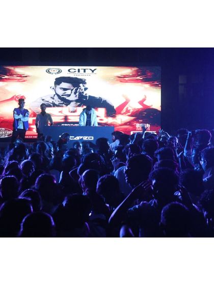 A view from the stage during a college festival. The large LED screen behind me features my branding, showing how I integrate visuals to create a complete and professional stage presence for any event.