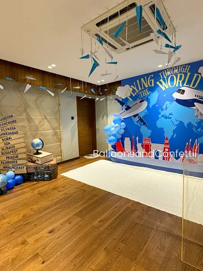 The complete travel-themed setup, with paper airplanes hanging from the ceiling and a corner dedicated to globes and vintage suitcases.