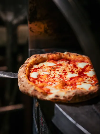 Fresh out of the oven and ready to go. This Margherita pizza is a testament to simple, high-quality ingredients cooked to perfection.