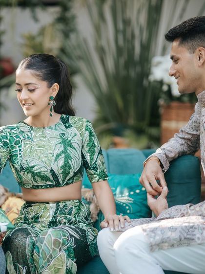 A jungle safari-themed Mehendi. The bride is wearing a unique green printed lehenga, and her makeup is kept natural and glowing to match the fun, outdoor vibe.