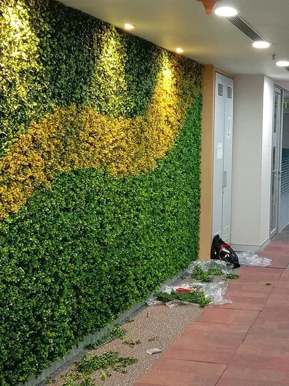 This custom artificial green wall in an office hallway uses a wave of yellow foliage to add a pop of color and energy to the workspace.