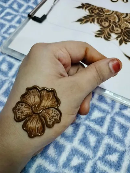 A single, perfectly executed hibiscus flower on the back of the hand. Practicing individual motifs like this is a great way to perfect your technique.
