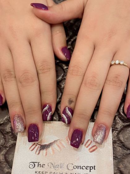 A rich purple polish on short square nails. The set is accented with full-coverage silver glitter nails and a white swirl design for contrast.