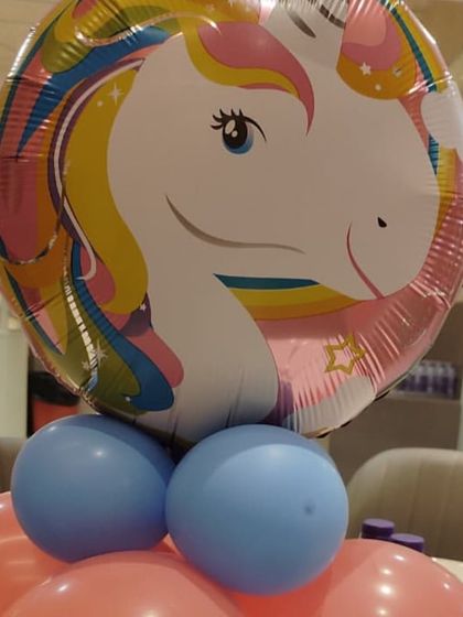 Even small details matter in a themed party. This is a close-up of a unicorn foil balloon centerpiece I created for a table setting, using pink and blue balloons as a base.