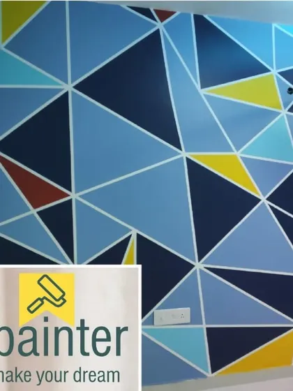 A bold geometric accent wall created with crisp lines and a modern color palette. This design uses various shades of blue, yellow, and red in a triangular pattern to make a powerful visual statement.
