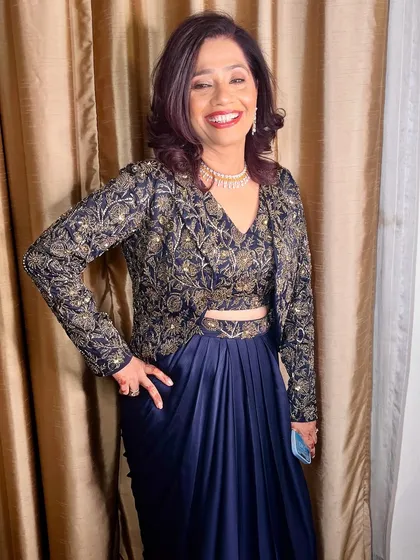 A full-length view of her stunning navy and gold outfit.
