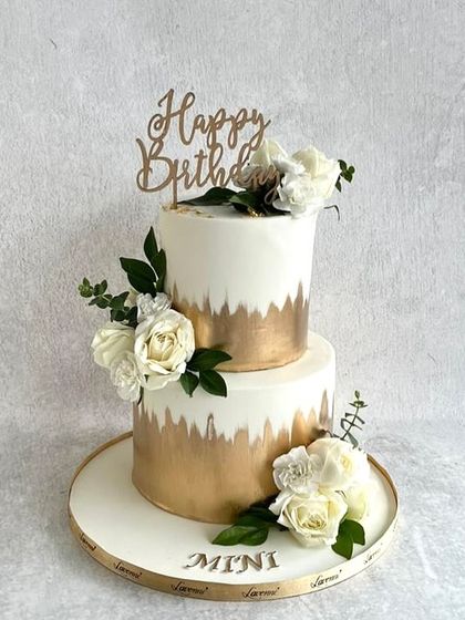 One of my classic designs that's perfect for any occasion. This two-tiered cake features a white and gold brushed effect, adorned with fresh white roses. Simple, elegant, and always beautiful.