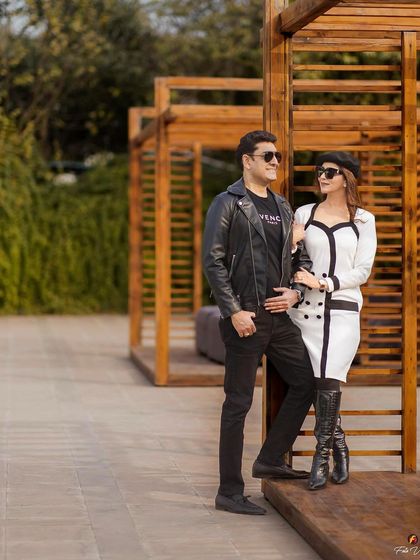 A full shot of the stylish couple. Her makeup is polished and sophisticated, perfect for this modern and fashionable pre-wedding theme.