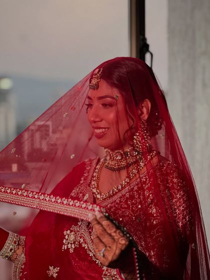 A beautiful, candid moment under the veil. The soft lighting catches the glow on her skin, showing how the makeup looks just as good in motion as it does in posed photos.