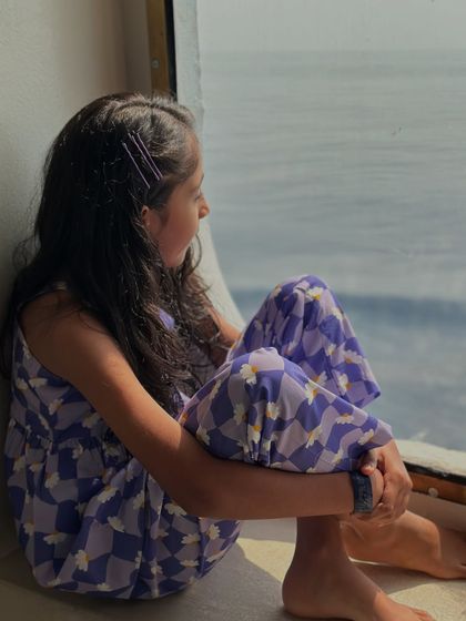 A quiet moment by the window. Our clothes are made for these real, everyday moments. This purple printed co-ord set is as comfortable for quiet reflection as it is for active play.