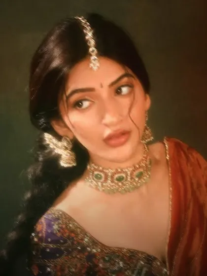 A vintage-inspired portrait of Sree Leela, looking ethereal in an emerald choker, winged earrings, and a delicate maang tikka.