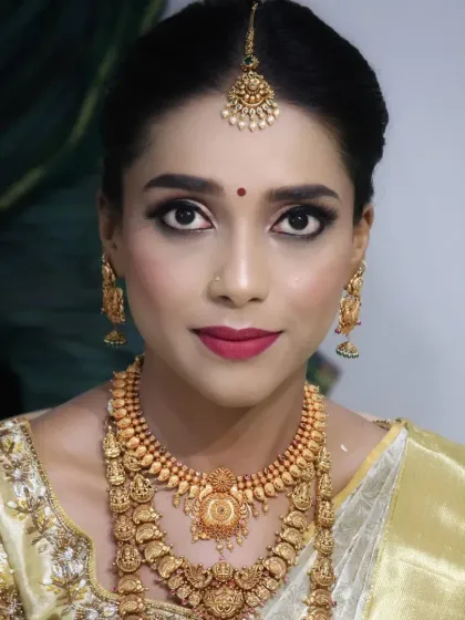 A striking portrait of a South Indian bride. Her eyes are beautifully defined with kohl and sharp eyeliner, paired with a bold red lip, creating a powerful and confident look that is perfect for a muhurtham ceremony.
