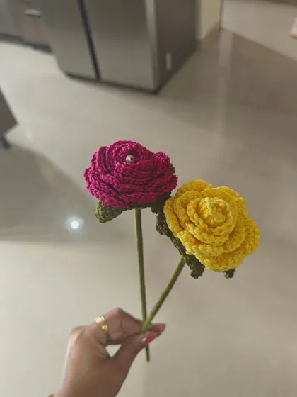 Holding up my two handcrafted roses to show their long stems, which makes them perfect for arranging in a vase.