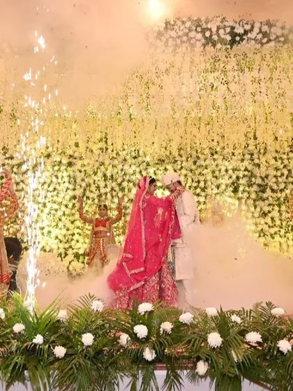 The climax of the Jaimala ceremony, with the bride garlanding the groom as pyrotechnics and smoke erupt around them. It's a moment of pure, unadulterated celebration that I love to create.