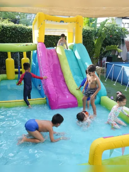 Making a splash at one of our signature pool parties. Our outdoor area transforms into a mini water park with inflatable slides and pools, perfect for beating the heat and creating unforgettable summer memories.