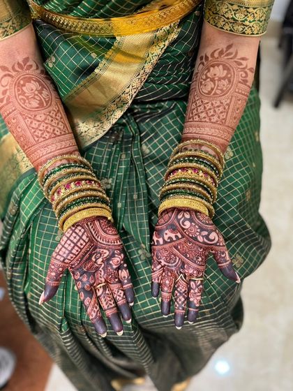 A stunning, dark mehendi stain paired with traditional green bangles. The rich color makes the intricate details of the elephants and lotuses pop.
