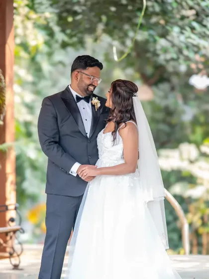 A classic, full-length wedding portrait in a lovely outdoor setting. The couple looks so happy and relaxed, ready to start their new life together.