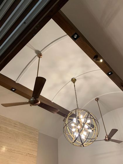 The ceiling design in this renovated Delhi home features exposed wooden beams and arched vaults, punctuated by a modern spherical chandelier. This combination of rustic structure and contemporary lighting is central to our adaptive reuse philosophy.