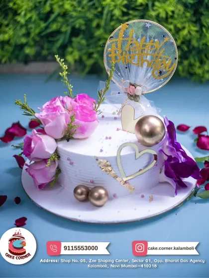 A beautiful white cake decorated with fresh pink and purple flowers and gold hearts. The delicate design makes it perfect for a romantic and elegant celebration.