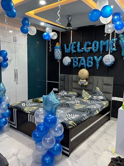 A full room decoration to welcome a baby boy. I used blue and white balloons to fill the space, with foil balloons spelling 'WELCOME BABY' over the bed and columns of balloons framing the room.