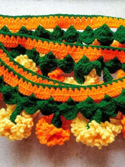 A thick, lush marigold toran, folded to show the density of the flowers and leaves I crochet into each piece.