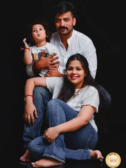 A striking family portrait using a bold, solid black background. This classic setup makes the family the complete focus, highlighting their connection and individual personalities.