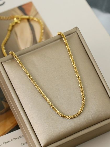 A product shot of my textured gold-tone chain necklace, displayed in its gift box. This piece is also available as a matching bracelet.