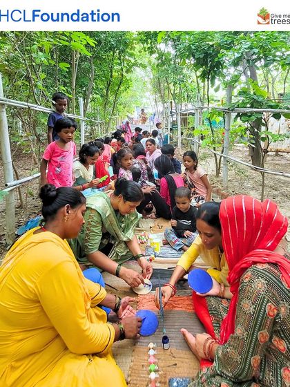 Women and children from the Sorkha community sit together, engrossed in the mirror art workshop. Art is a wonderful way to bring communities together in a natural setting.